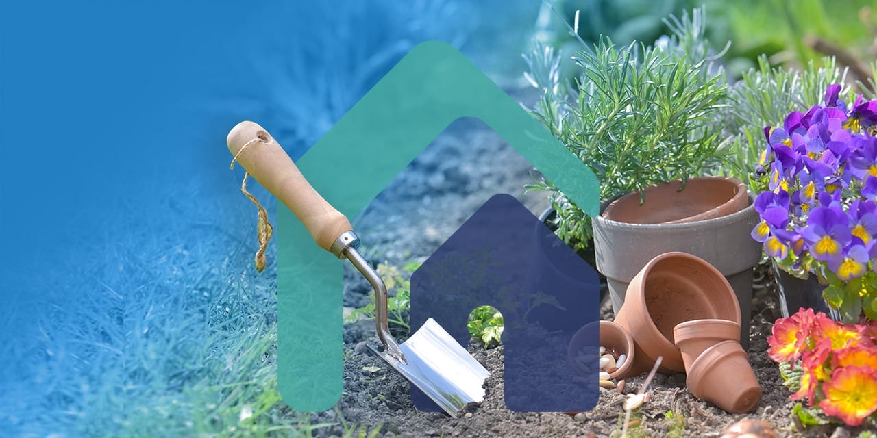 shovel planting in the soil next to teracotta pots and flowers with copy space in grass